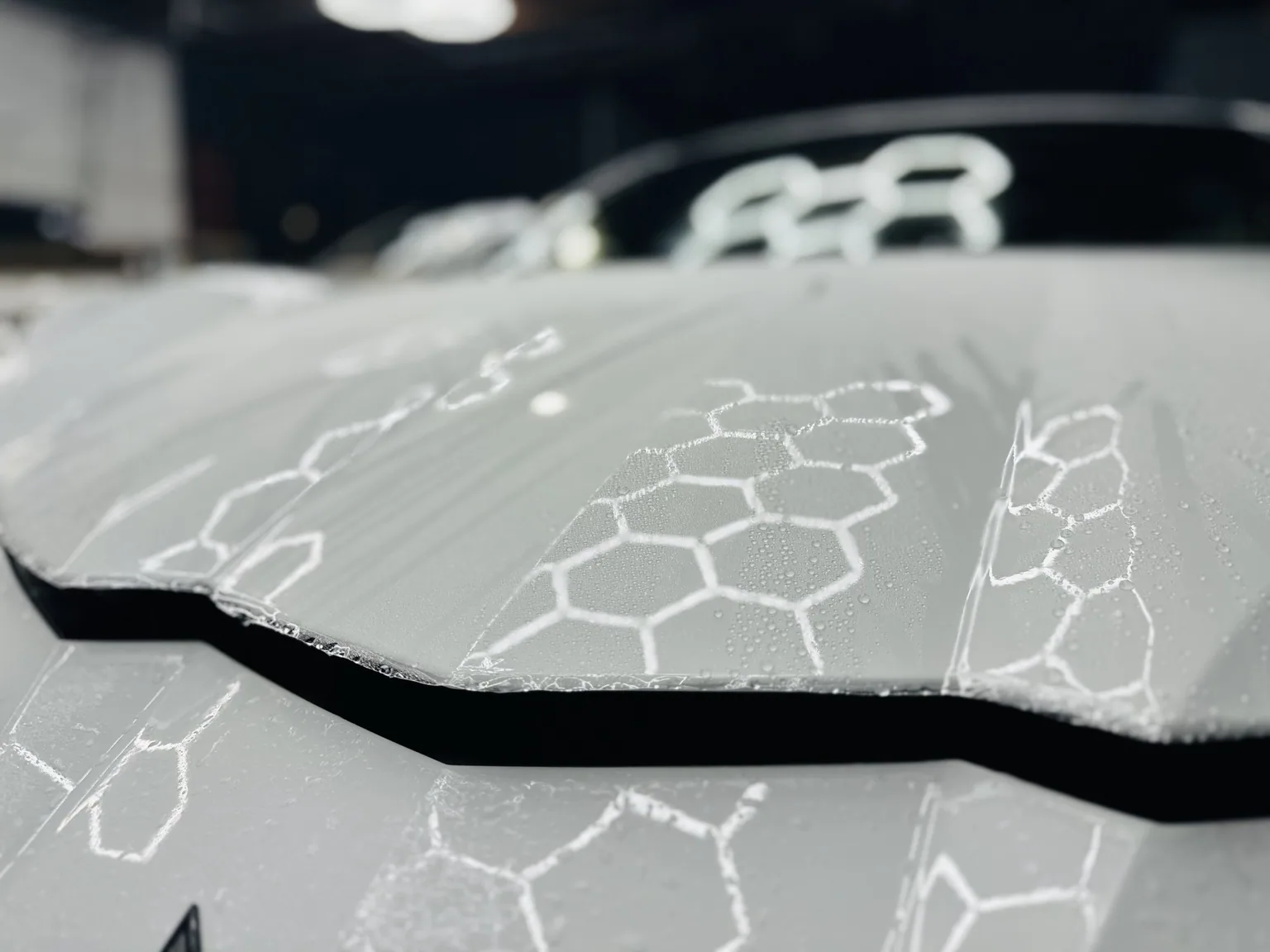 Vehicle hood inside an auto protection workshop
