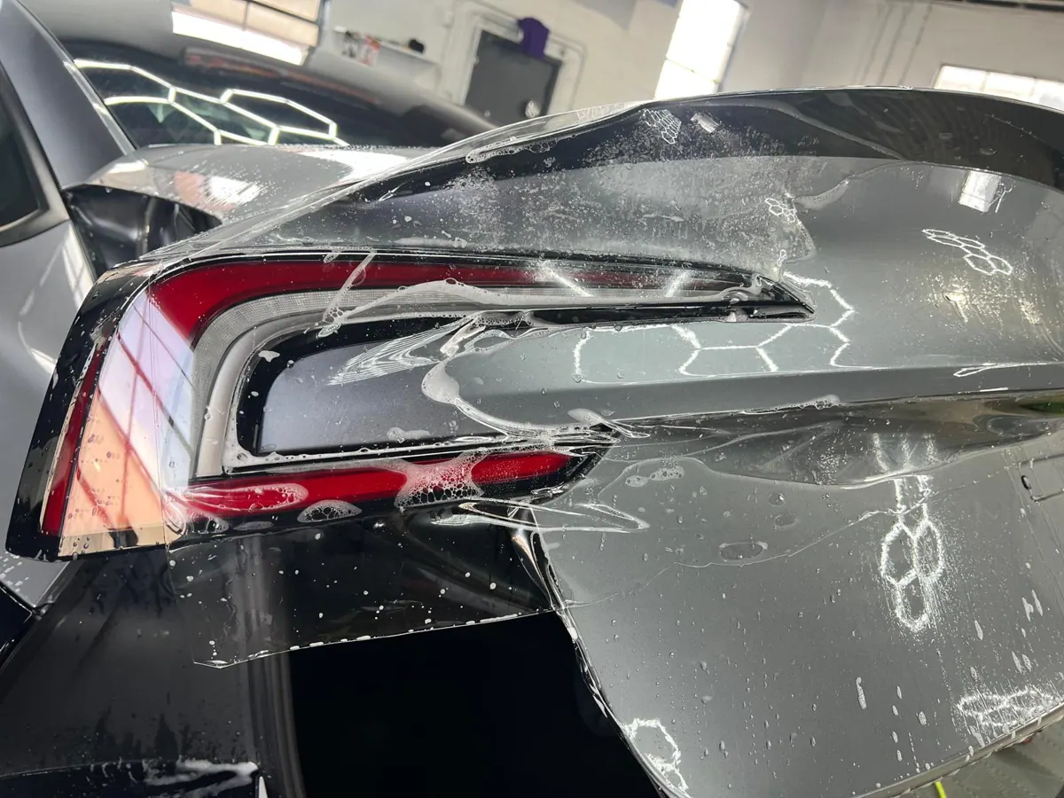 Clear film positioned on a vehicle panel.