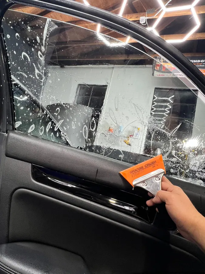 Window film installation on vehicle glass.